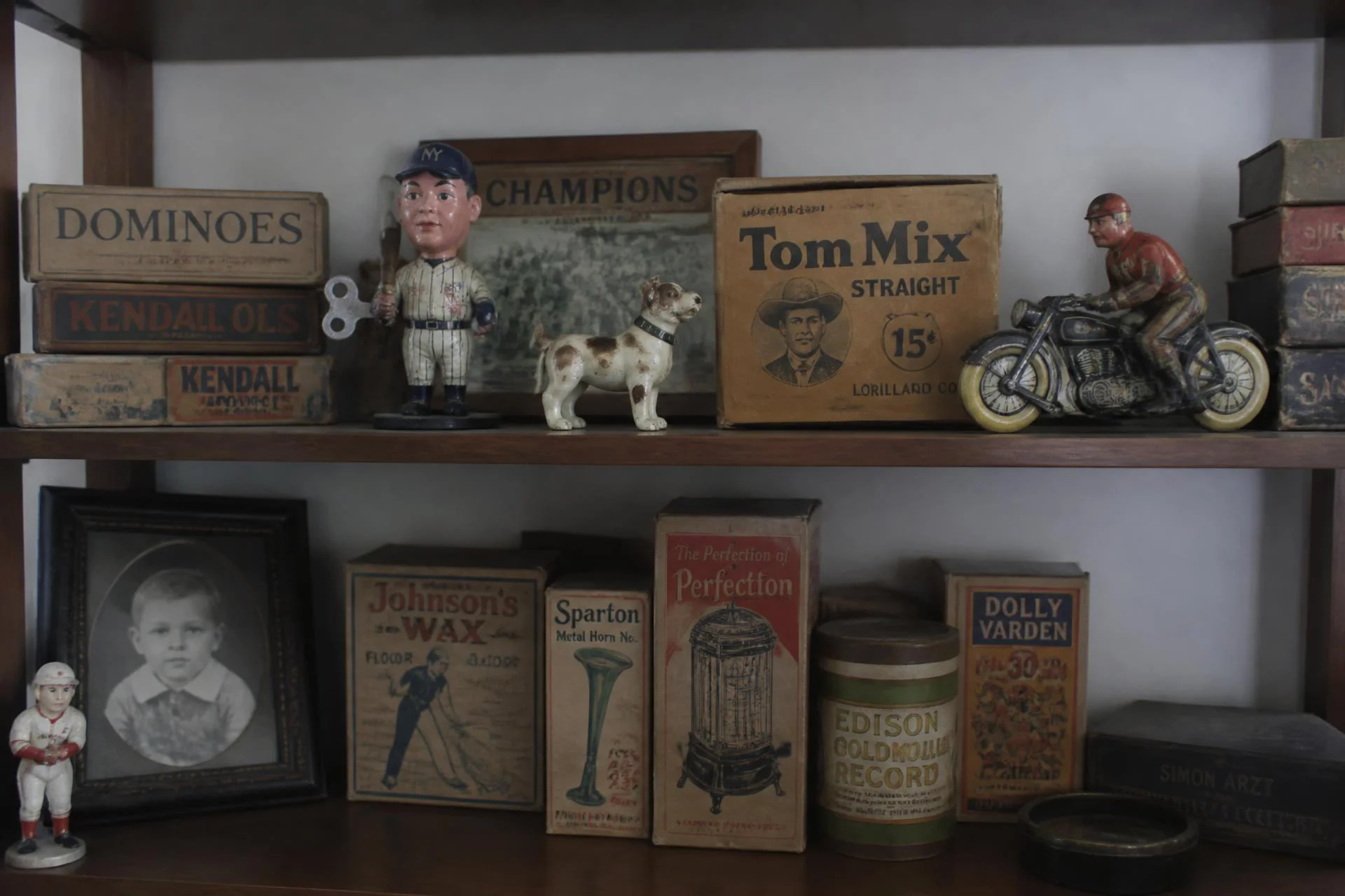 Shelf of antique toys, boxes and paper ephemera in a collector home