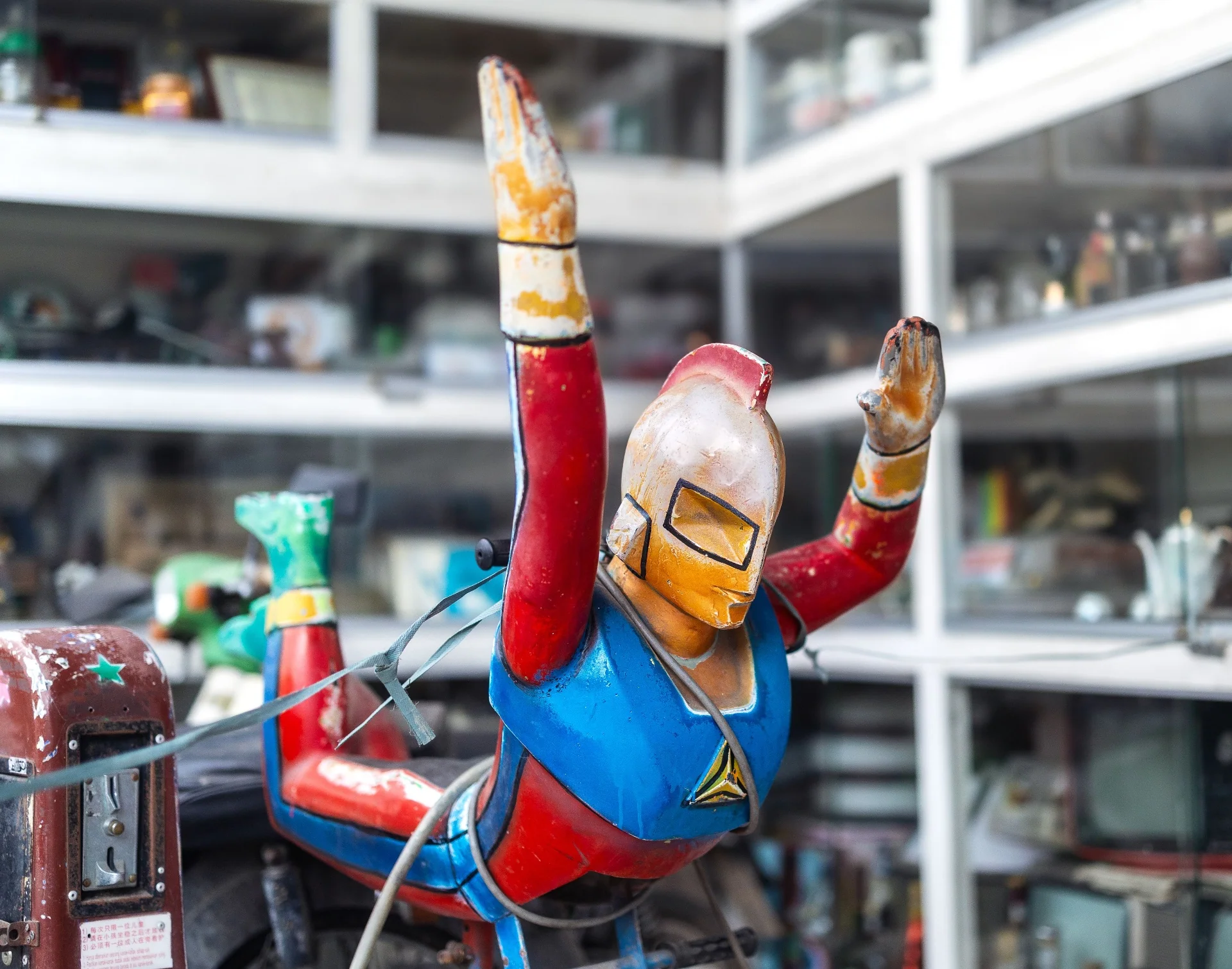 Vintage painted tin superhero toy in a collector shop